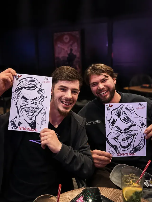Doi prieteni cu caricaturile lor, la un eveniment seara