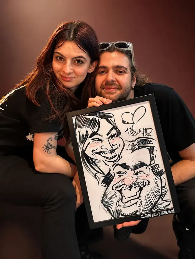 Un cuplu cu caricatura lor pusă într-o ramă